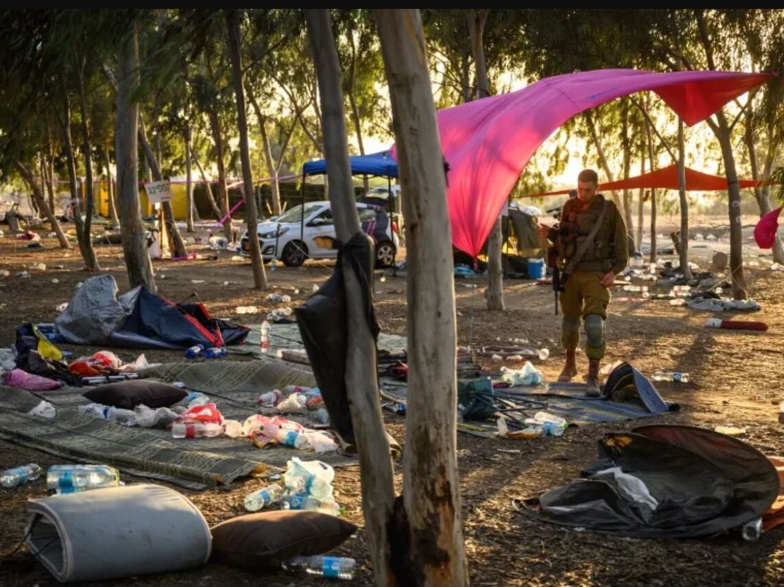 An Israeli soldier stands in the destroyed NOVA Festival campground