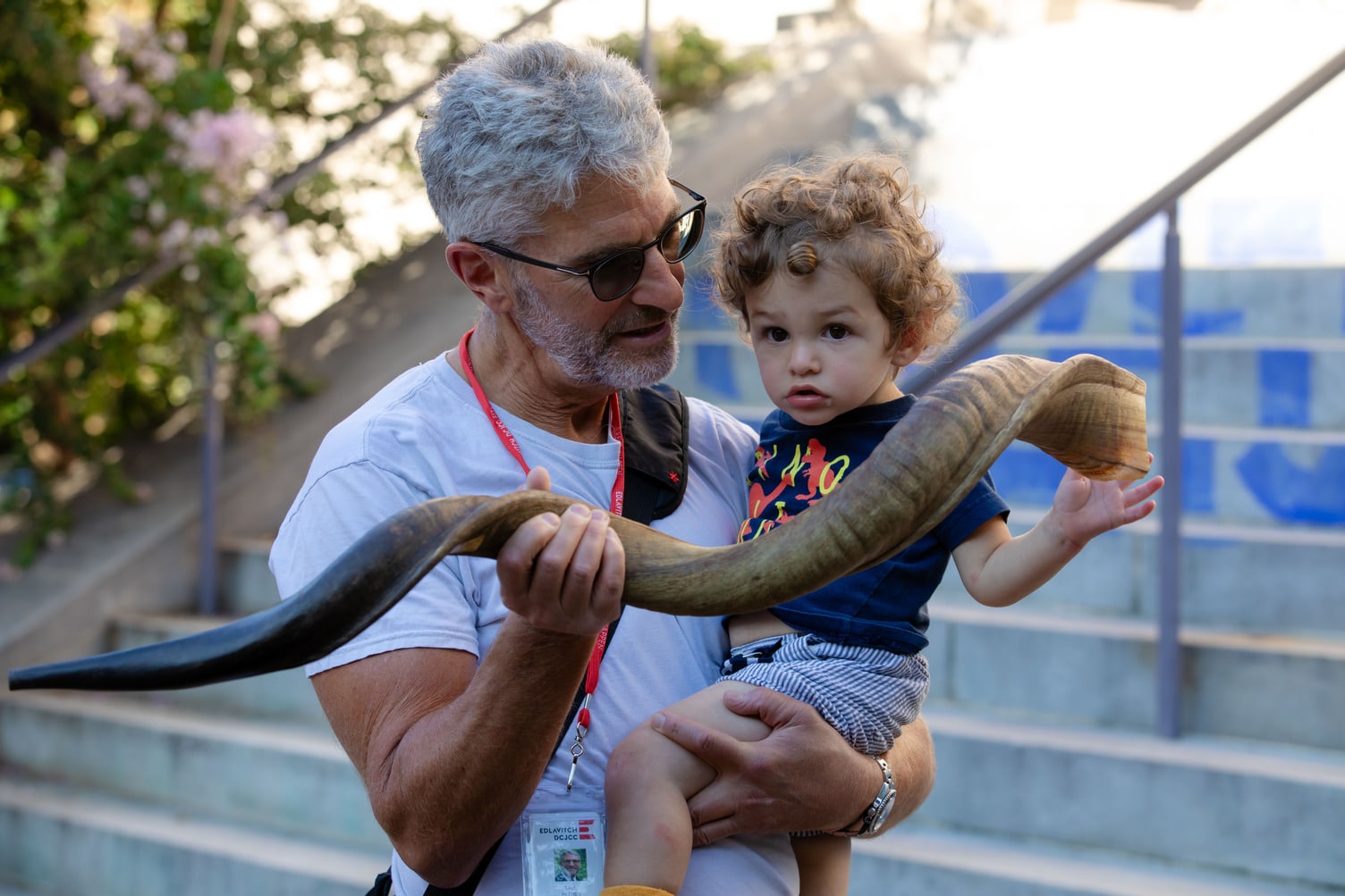 A man holding a toddler and a shofar