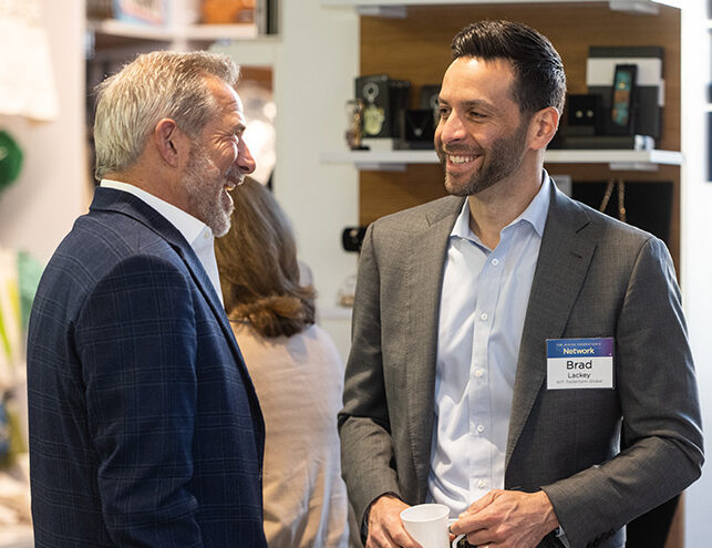 Two multigenerational men speaking to one another.