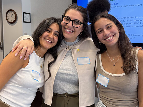 Group of three shlichim smile for the camera.