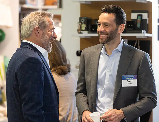 Two multigenerational men speaking to one another.